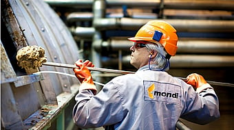 A Mondi employee picks up residues from wood fibres, chemicals and other substances.