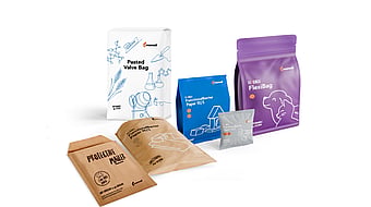 Collection of Mondi paper-based packaging solutions displayed on a light grey background, including a white pasted valve bag with blue illustrations, a blue stand-up pouch, a purple re/cycle FlexiBag pouch, a brown FunctionalBarrier paper pouch, a brown protective paper mailer, and a small grey sachet. The packaging features sustainability-focused branding, line drawings, and re/cycle product labels.